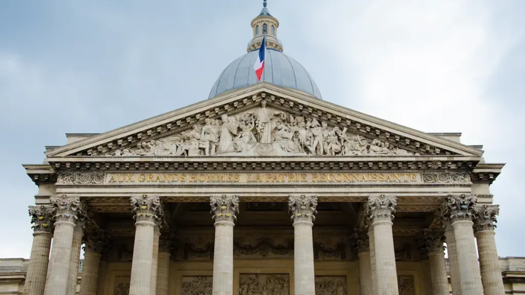 Façade néoclassique d'un bâtiment officiel français avec le drapeau tricolore au sommet.