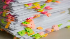 Piles de dossiers administratifs organisés avec des onglets de couleurs vives.